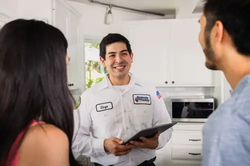 Benjamin Franklin Plumbing Tech, Diego, Speaking with homeowners at their home in Fort Myers