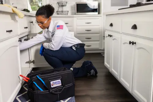 Benjamin Franklin Plumbing Tech, Layla, working under a sink in a home in Fort Myers